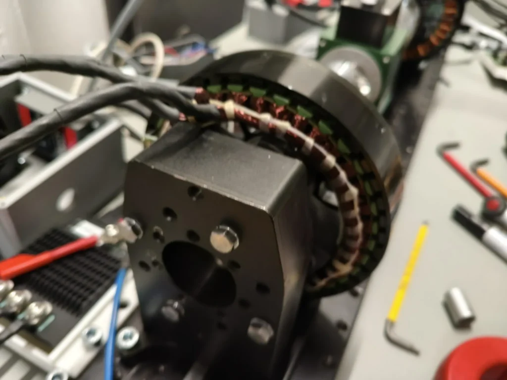 Outrunner motor with visible winding on the test bench, flanged to the measuring shaft